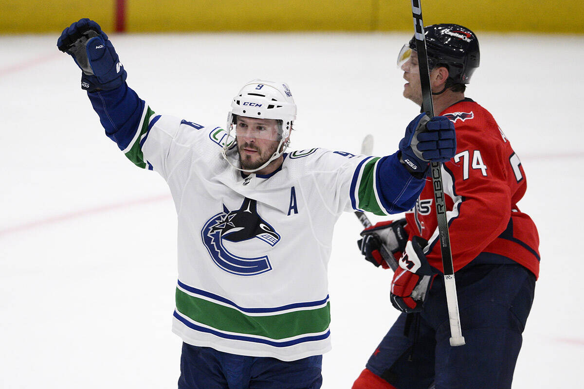 Vancouver Canucks centre J.T. Miller (9) celebrates after his winning goal during overtime of an NHL hockey game in front of Washington Capitals defenceman John Carlson (74), Sunday, Feb. 11, 2024, in Washington. (AP Photo/Nick Wass)