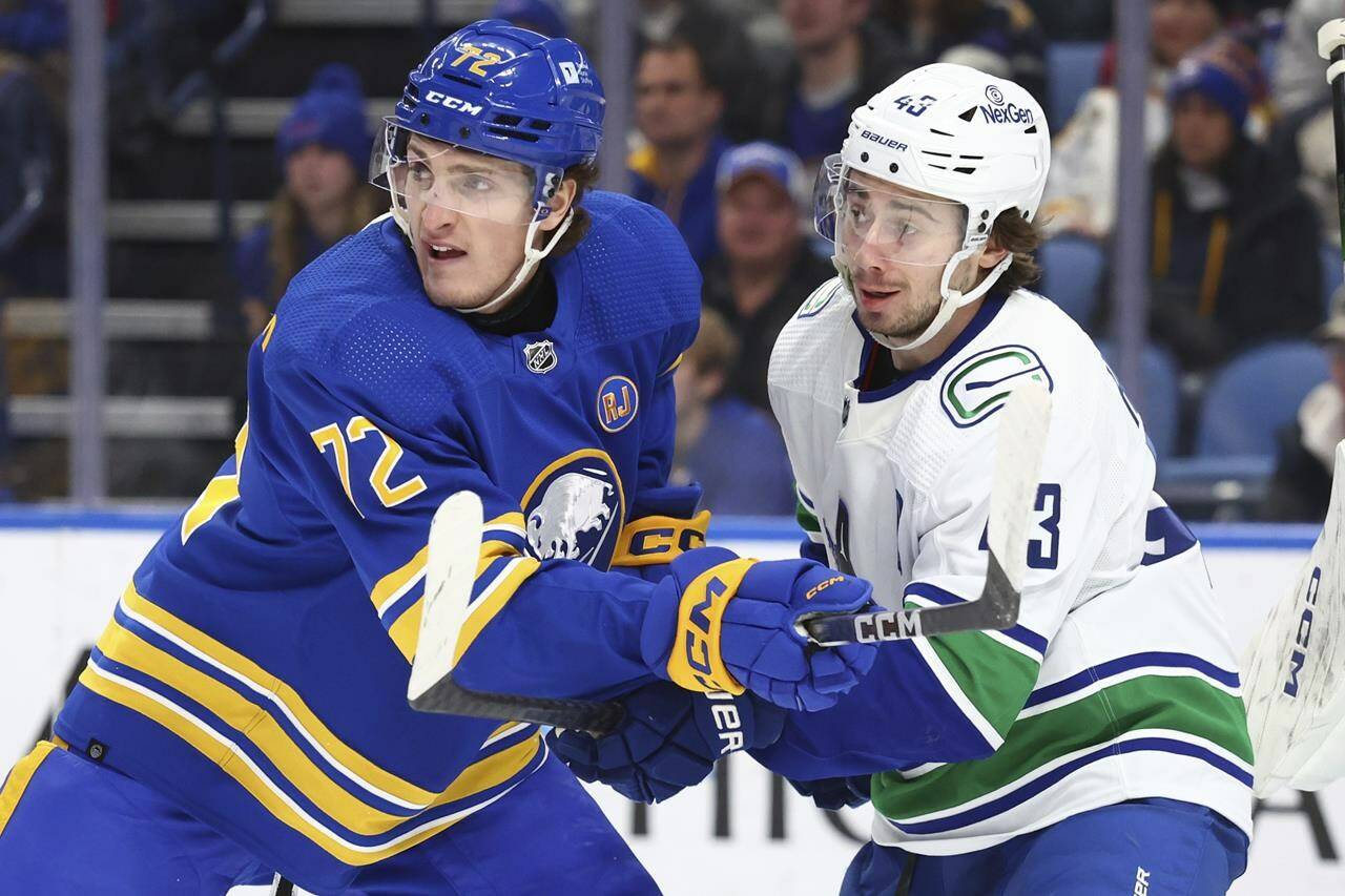 Buffalo Sabres right wing Tage Thompson (72) and Vancouver Canucks defenseman Quinn Hughes (43) battle for position in front of the net during the first period of an NHL hockey game Saturday, Jan. 13, 2024, in Buffalo, N.Y. (AP Photo/Jeffrey T. Barnes)