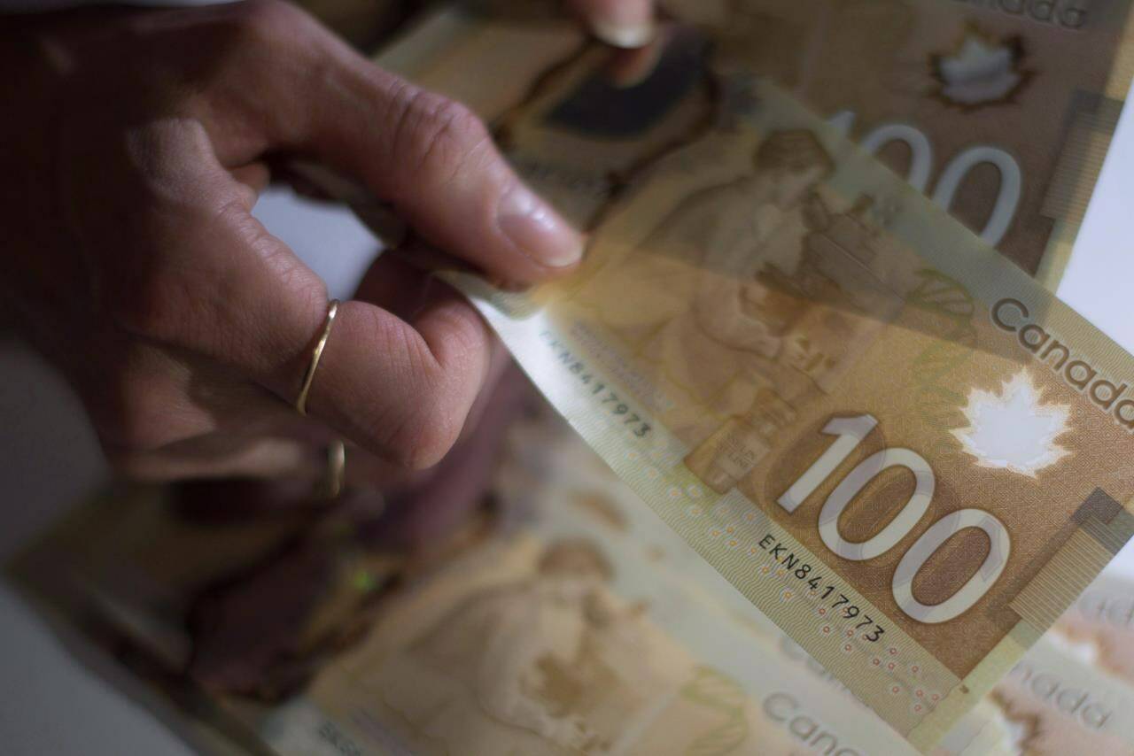 Canadians are stressed out about the economy and have little faith in politicians or governments to fix big problems, a new survey suggests. Canadian $100 bills are counted in Toronto on Tuesday, Feb. 2, 2016. THE CANADIAN PRESS/Graeme Roy