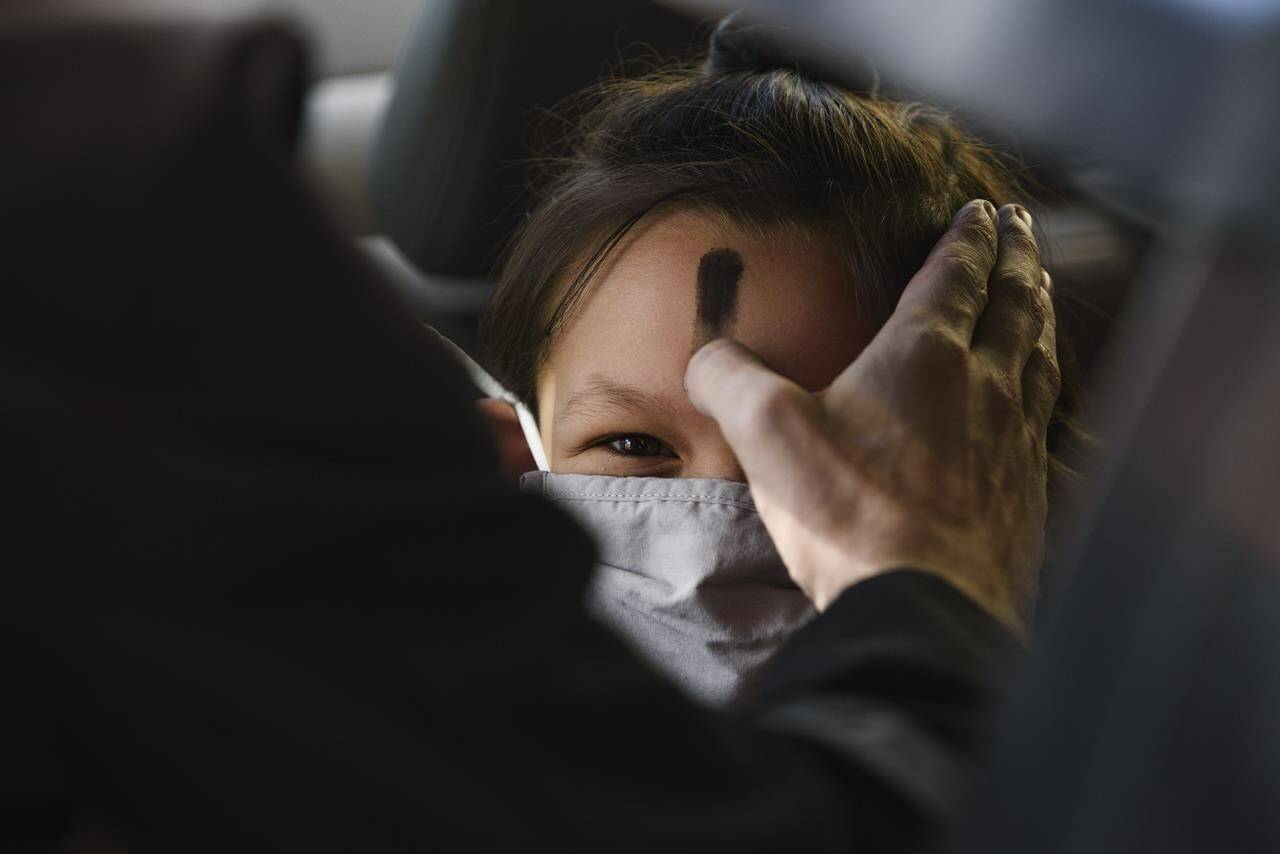 FILE - Zoe Gutierrez receives ashes on her forehead for Ash Wednesday, March 2, 2022, in Odessa, Texas. In 2024, Feb. 14 is a holiday heavyweight due to a calendar collision of events — it’s Valentine’s Day and Ash Wednesday. (Eli Hartman/Odessa American via AP, File)