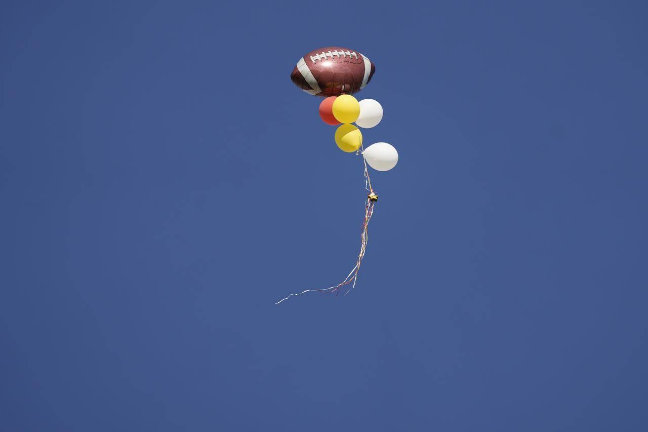 A football balloon drifts in the sky following the Kansas City Chiefs victory parade in Kansas City, Mo., Wednesday, Feb. 14, 2024. The Chiefs defeated the San Francisco 49ers Sunday in the NFL Super Bowl 58 football game. (AP Photo/Charlie Riedel)