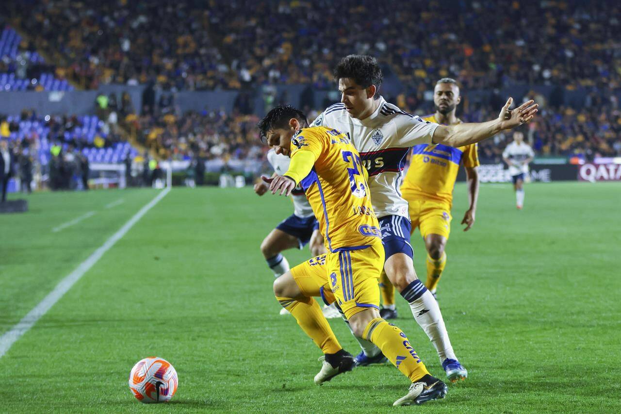 Jesus Angulo of Mexico’s Tigres, left, and Brian White of Canada’s Vancouver Whitecaps compete for the ball during a CONCACAF Champions Cup soccer match in Monterrey, Mexico, Wednesday, Feb. 14, 2024. (AP Photo/Jorge Mendoza)