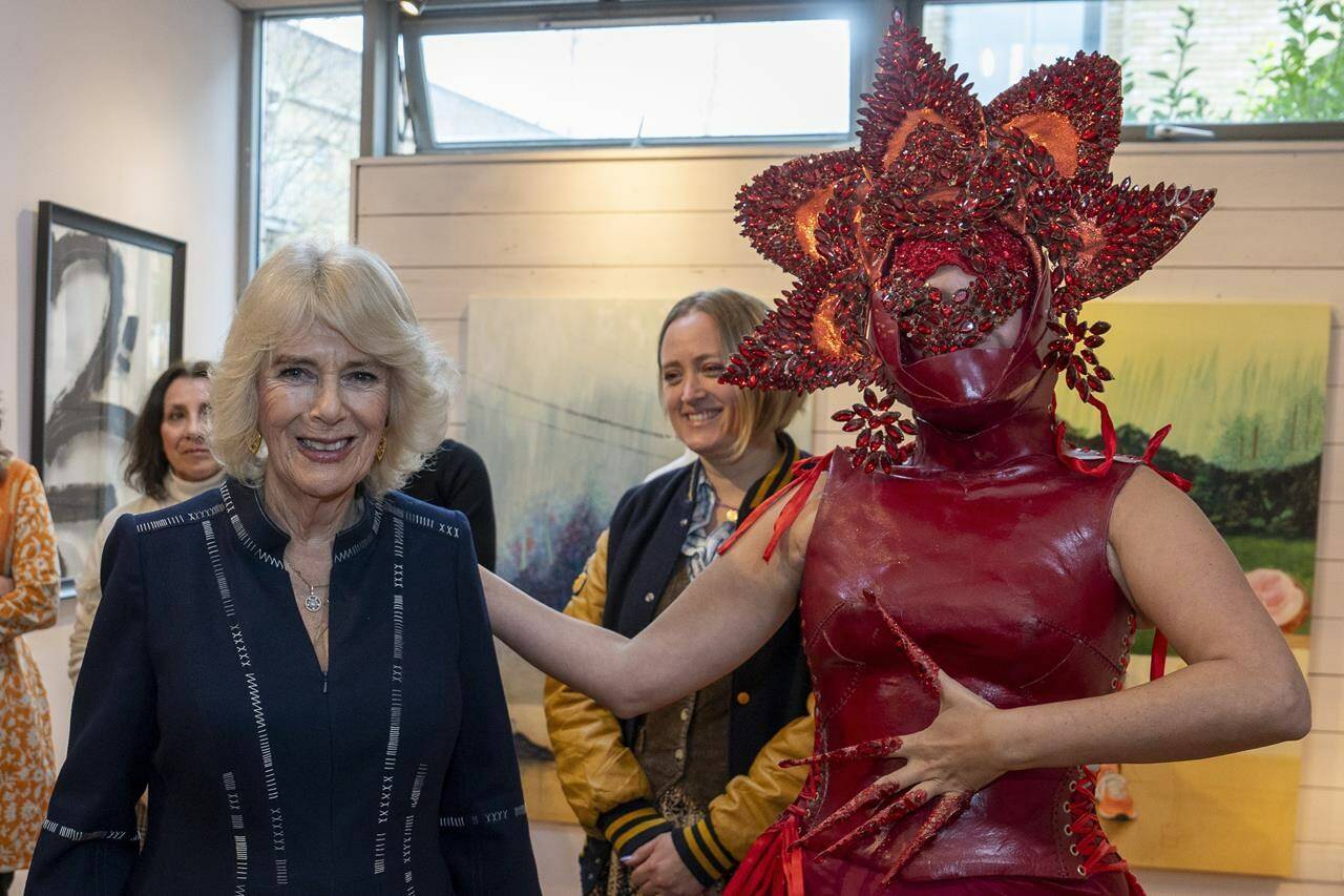 FILE - Britain’s Queen Camilla, left, meets costume designer Syban Velardi-Laufer during her visit to Kindred Studios’ Shepherds Bush pop-up hub, an art studios and creative space encouraging arts, crafts and community cohesion, in London, Wednesday, Feb. 14, 2024. Queen Camilla, once seen as the scourge of the House of Windsor, the woman at the heart of King Charles III’s doomed marriage to the late Princess Diana, has emerged as one of the monarchy’s most prominent emissaries. (Arthur Edwards/Pool Photo via AP, File)