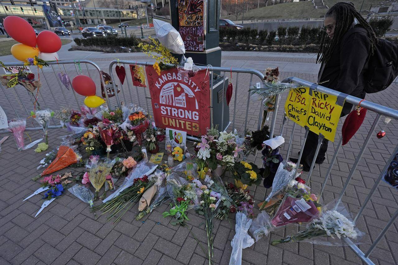 A person views a memorial dedicated to the victims of last week’s mass shooting in front of Union Station, Sunday, Feb. 18, 2024, in Kansas City, Mo. Authorities say two juveniles have been charged with crimes connected to the shooting at the Kansas City Chiefs’ Super Bowl rally. (AP Photo/Charlie Riedel)