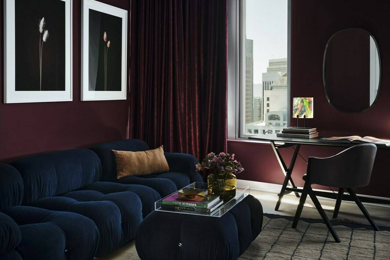 This image provided by frenchCalifornia shows a living room. A San Francisco home done by interiors firm frenchCalifornia, features this stylish space painted in Backdrop’s Lobby Scene, a dark, warm purple-red that was inspired by Wes Anderson’s The Grand Budapest Hotel and the color of the lobby boy’s uniform. (frenchCalifornia/Douglas Friedman via AP)