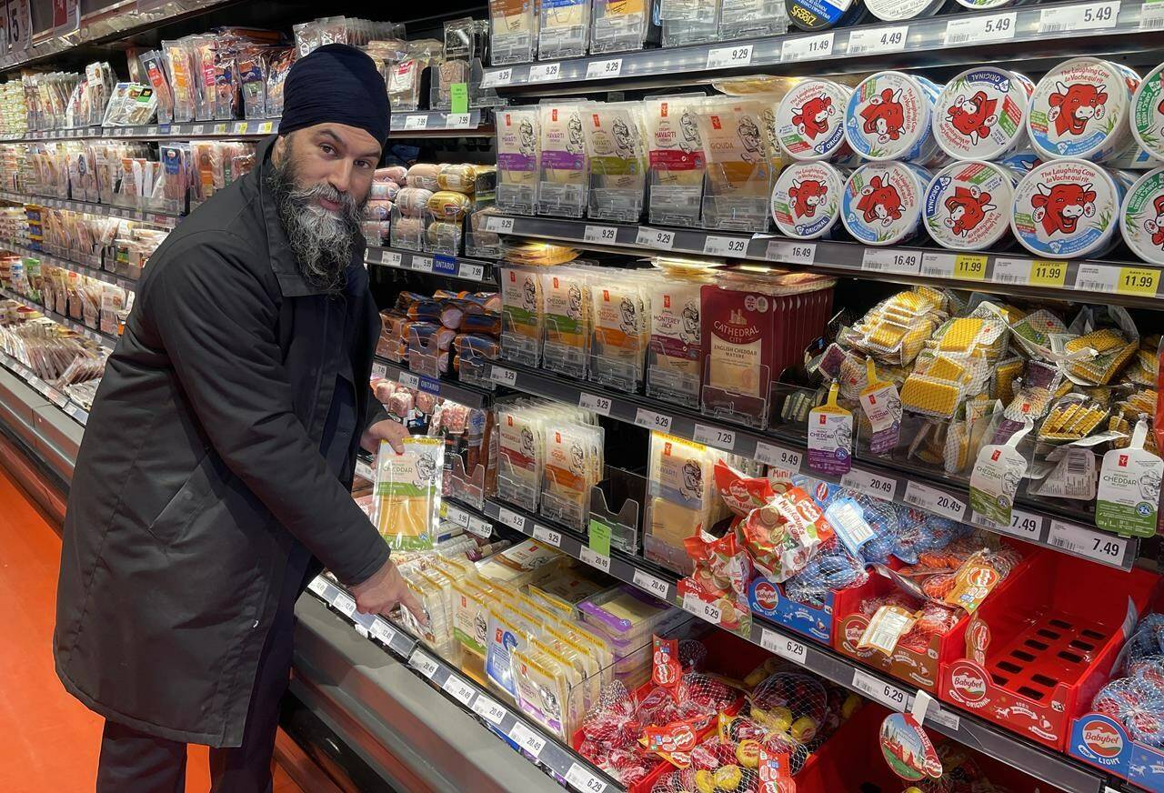 NDP Leader Jagmeet Singh points to a $20 pack of cheese during a visit to a Loblaws grocery store in Ottawa, which he believes is a reflection of grocery chains price gouging consumers on Wednesday Feb. 21, 2024. THE CANADIAN PRESS/Mickey Djuric