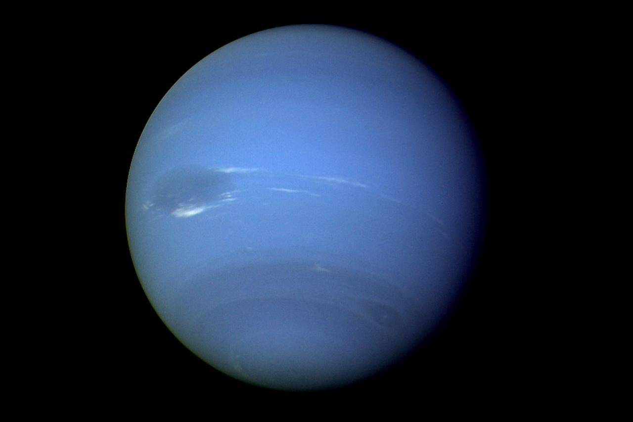 This August 1989 image provided by NASA shows the planet Neptune photographed by the Voyager 2 spacecraft, processed to enhance the visibility of small features. The International Astronomical Union’s Minor Planet Center announced Friday , Feb. 23, 2024, that astronomers have found three previously unknown moons in our solar system — two additional moons circling Neptune and one around Uranus. (NASA via AP)