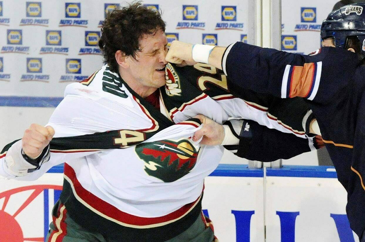 FILE - Minnesota Wild left wing Derek Boogaard (24), left, gets hit by Edmonton Oilers left wing Steve MacIntyre in a fight during first period NHL hockey action in Edmonton, Canada on Friday Jan. 30, 2009. The deaths of old-school enforcers like Derek Boogaard and Bob Probert, who were posthumously found to have chronic traumatic encephalopathy, or CTE, has changed some minds when it comes to glorifying fighting the way it used to be. (AP Photo/The Canadian Press, Jimmy Jeong)