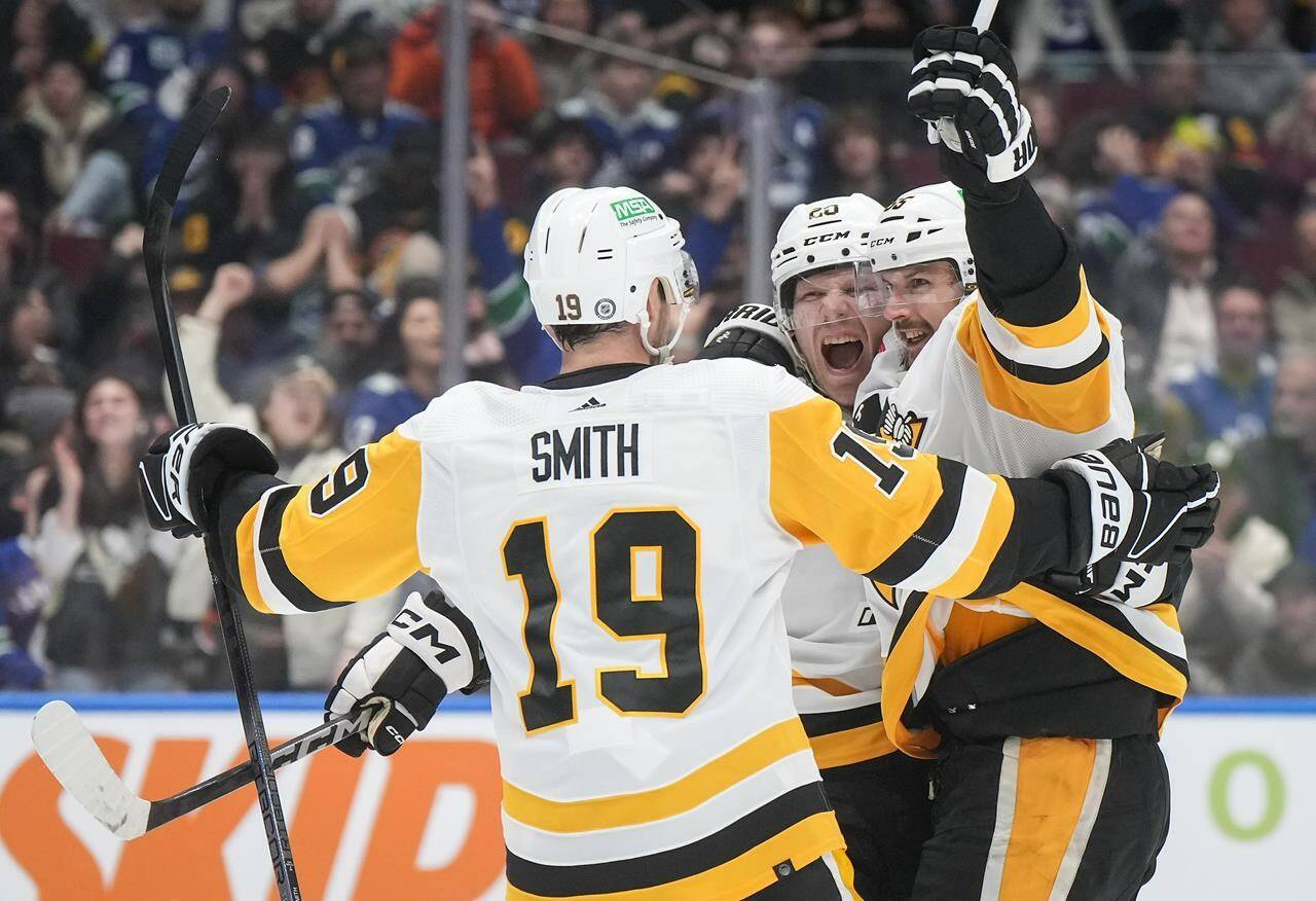 Pittsburgh Penguins’ Erik Karlsson, right, Lars Eller, back centre, and Reilly Smith celebrate Karlsson’s winning goal during overtime NHL hockey action against the Vancouver Canucks, in Vancouver, on Tuesday, February 27, 2024. THE CANADIAN PRESS/Darryl Dyck