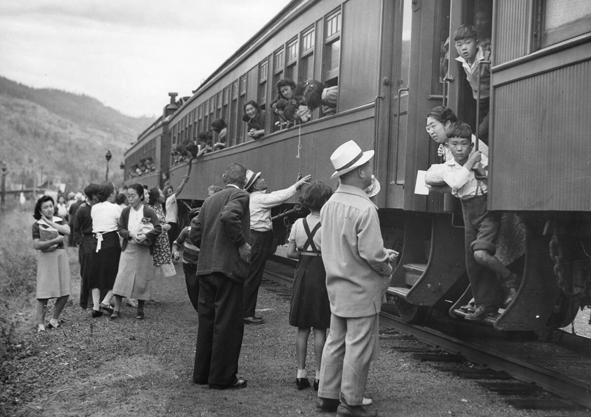 Displaced Japanese Canadians leaving the Vancouver area after being prohibited by law from entering a protected area within 100 miles of the coast in BC. This archival photo was featured in the Broken Promises exhibit at the Nikkei National Museum & Cultural Centre on Sept. 26, 2020. When did the federal government issue an apology for the internment of Japanese Canadians? (Image provided courtesy of NNMCC.)