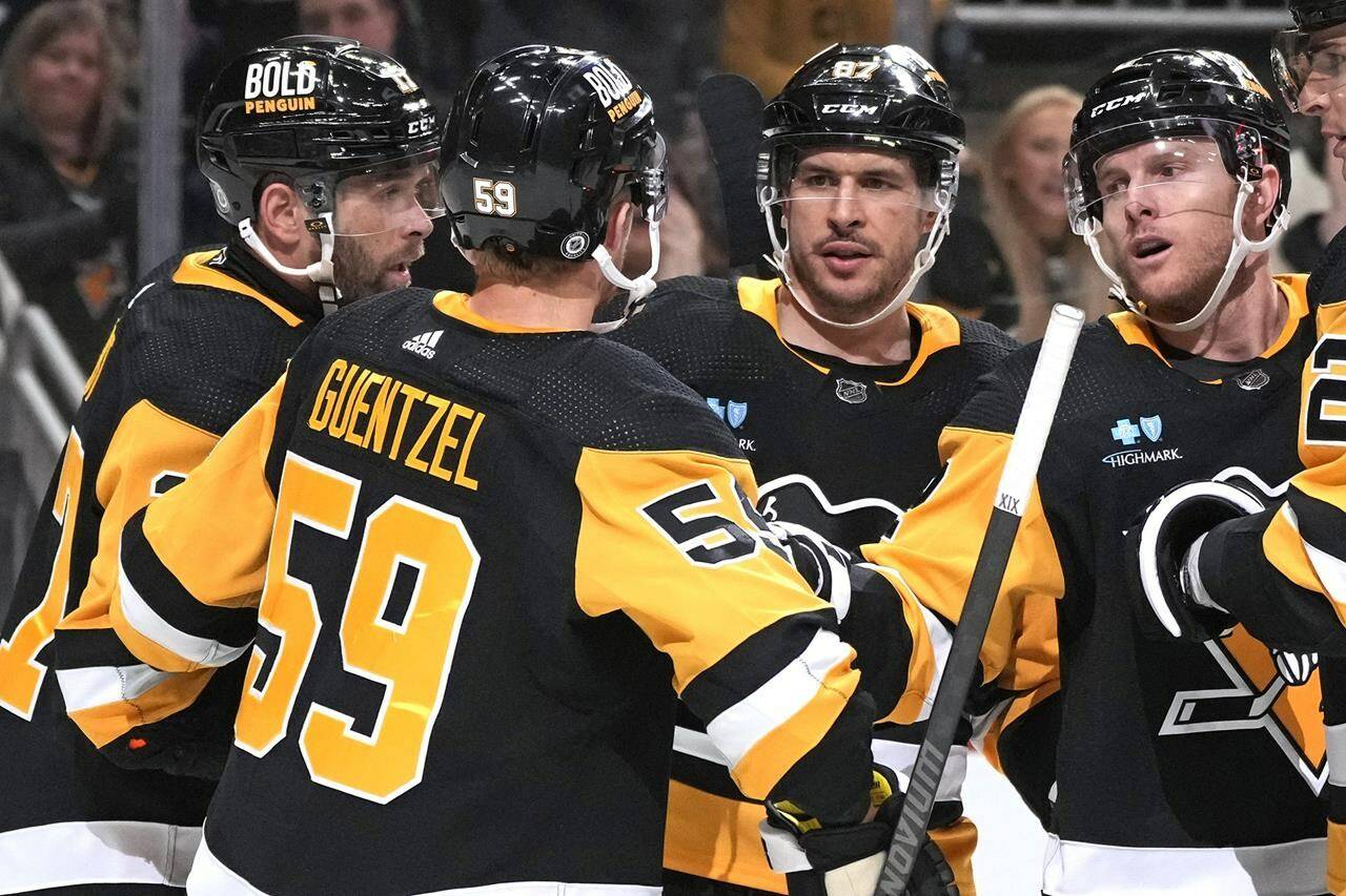Pittsburgh Penguins’ Jake Guentzel (59) celebrates with Bryan Rust, left, Sidney Crosby (87), and Chad Ruhwedel after scoring during the second period of an NHL hockey game against the Florida Panthers in Pittsburgh, Wednesday, Feb. 14, 2024. The Panthers won 5-2. (AP Photo/Gene J. Puskar)