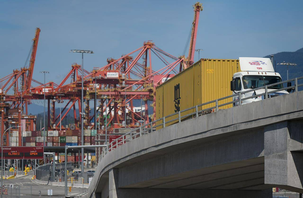 A new report finds that rising costs in trucking have overtaken the driver shortage as the biggest concern for employers in the sector. A transport truck carries a cargo container from the Centerm Container Terminal at port in Vancouver, on Friday, July 14, 2023. THE CANADIAN PRESS/Darryl Dyck