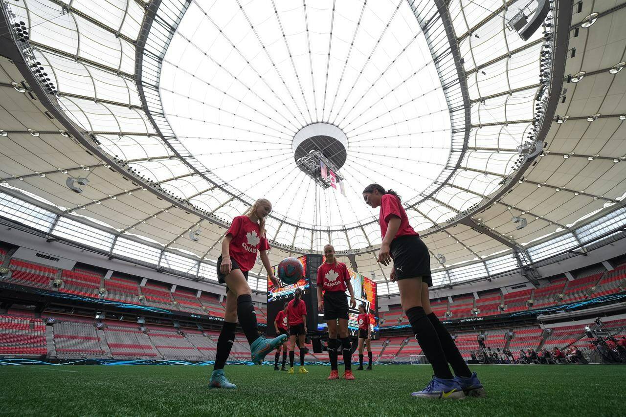 Youth soccer players kick a ball around on the field at B.C. Place stadium during a gathering to watch Vancouver be chosen as one of the host cities for the 2026 FIFA World Cup, in Vancouver, on Thursday, June 16, 2022.The city of Vancouver says it’s unable to give a complete estimate of costs associated with hosting 2026 FIFA World Cup matches, due to hosting two more games than originally anticipated.THE CANADIAN PRESS/Darryl Dyck