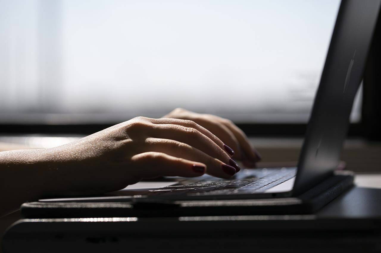 FILE - This May 18, 2021, photo shows a woman typing on a laptop on a train in New Jersey. Becoming self-employed can be an exciting journey, but it’s also possible to make expensive mistakes. These mistakes can create financial setbacks that stunt your growth or impact your financial security in the present and future if caution isn’t taken. (AP Photo/Jenny Kane, File)