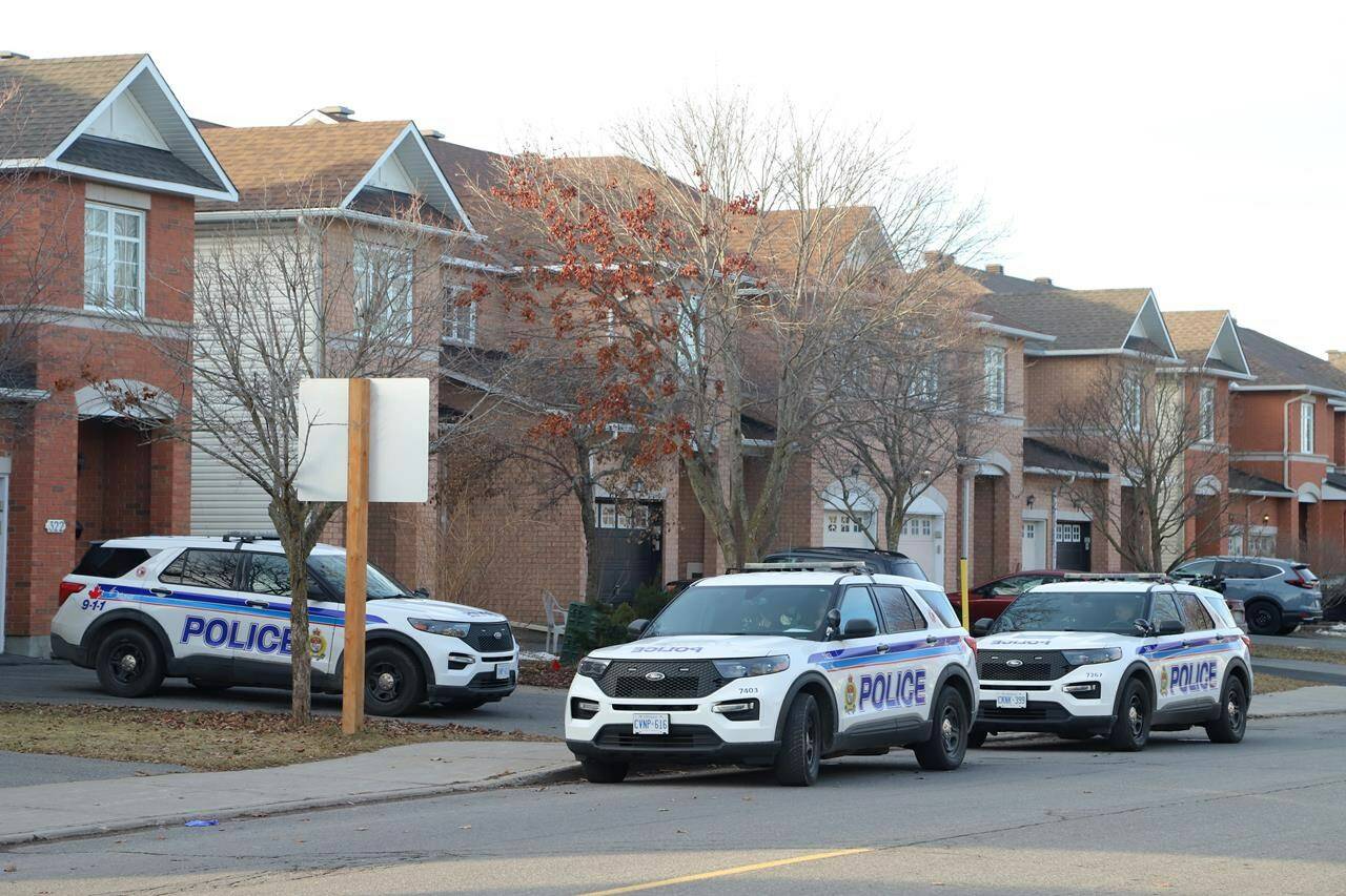 Police vehicles are parked at the scene of a homicide where six people were found dead in the Barrhaven suburb of Ottawa on Thursday, March 7, 2024. THE CANADIAN PRESS/ Patrick Doyle