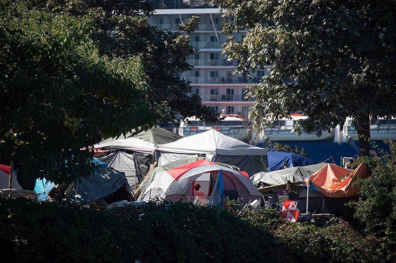 Vancouver officials say the dozens of homeless people staying in the city’s only legal encampment have to temporarily move out because the space has become unsafe and unhygienic. A person sits in a tent at a homeless encampment at Crab Park in Vancouver, on Sunday, Aug. 14, 2022. THE CANADIAN PRESS/Darryl Dyck