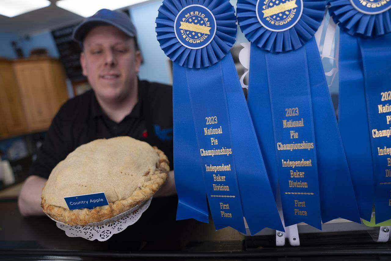 Manager Stephen Jarrett displays their National Pie Championships 1st place winning country apple pie at Michele’s Pies, Wednesday, March 13, 2024, in Norwalk, Conn. Math enthusiasts and bakers celebrate Pi Day on March 14 or 3/14, the first three digits of a mathematical constant with many practical uses. Around the world many people will mark the day with a slice of sweet or savory pie. (AP Photo/John Minchillo)