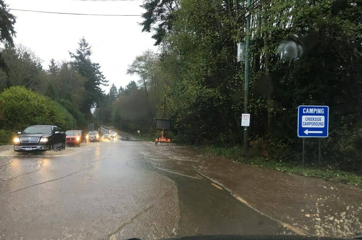 Cars move through floodwater along the Sunshine Coast Highway near Sechelt, B.C., during the atmospheric river event in a November 2021 handout photo. (Ross Muirhead/Contributed)