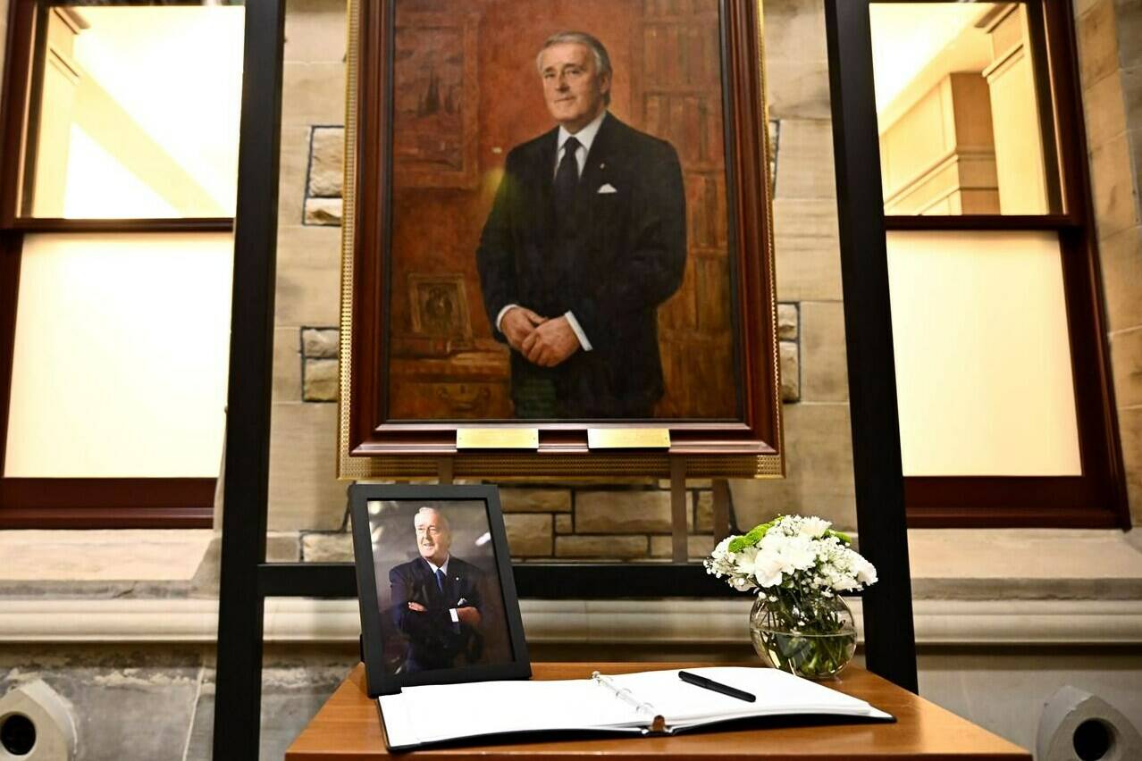 A photograph and book of condolences for Members of Parliament to sign are seen in front of the official portrait of former prime minister Brian Mulroney, in the antechamber to the House of Commons on Parliament Hill as Canadians mourn his death on Thursday at the age of 84, in Ottawa, Friday, March 1, 2024. THE CANADIAN PRESS/Justin Tang