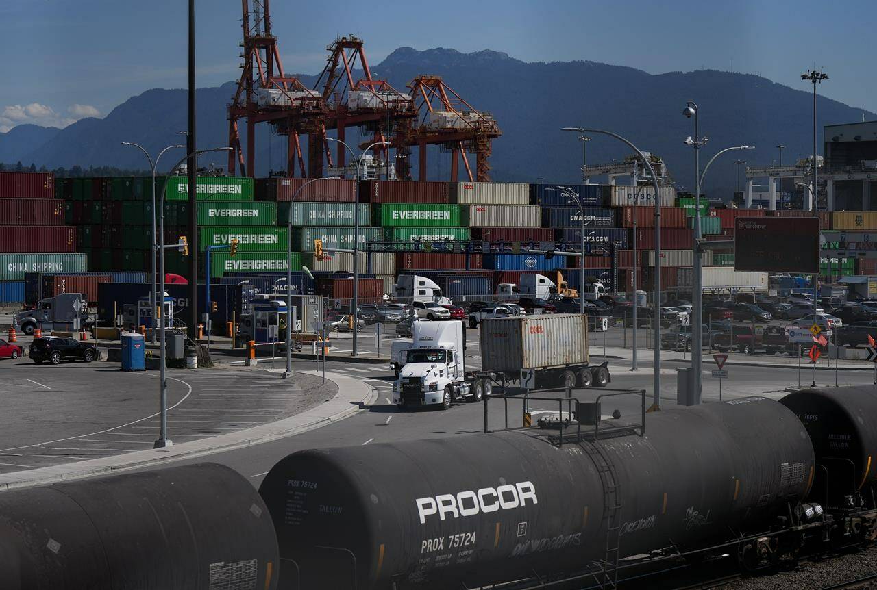 The Vancouver Fraser Port Authority says a record cargo volume rolled through its terminals last year, despite a sputtering global economy and a big drop in container shipments. Transport trucks carry cargo containers at port in Vancouver, on Friday, July 14, 2023. THE CANADIAN PRESS/Darryl Dyck