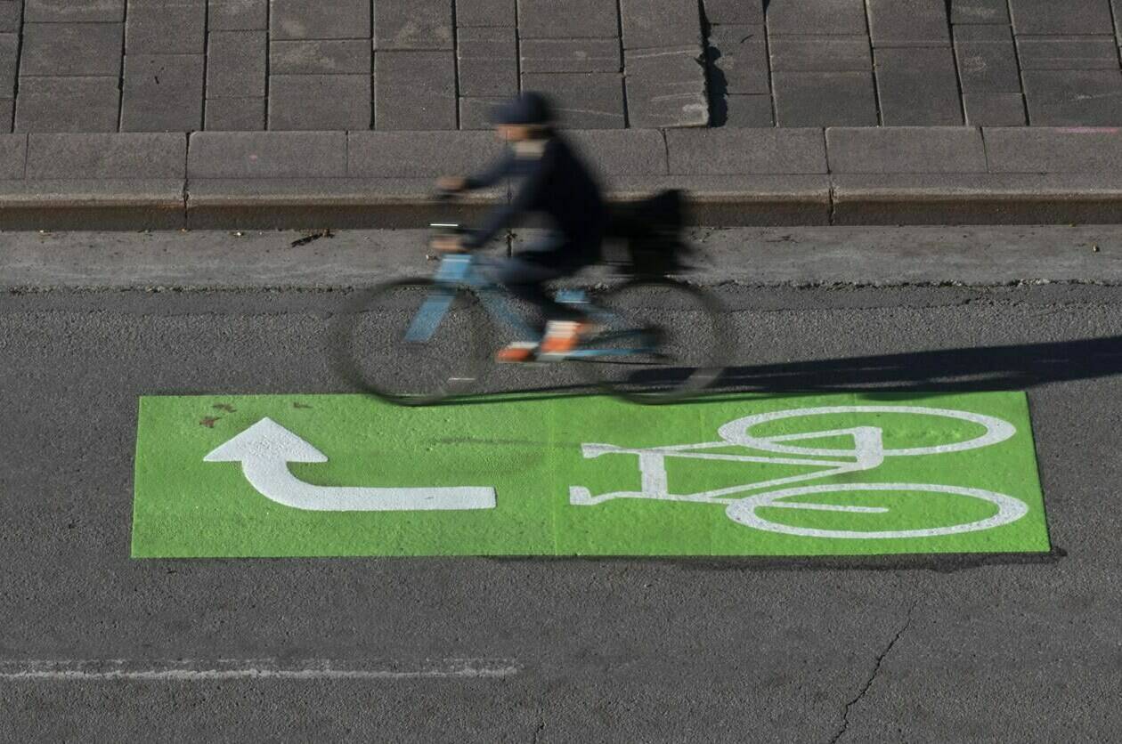 A cyclist makes their way along a roadway in a lane marked for bicycles, Wednesday, Nov. 2, 2022 in Ottawa. Bodies and minds are just as affected by climate change as sea ice and forests, says University of Alberta scientist Sherilee Harper. THE CANADIAN PRESS/Adrian Wyld