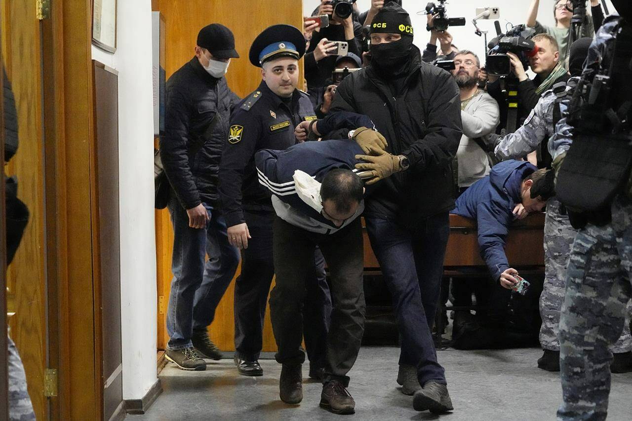 Saidakrami Murodali Rachabalizoda, a suspect in the Crocus City Hall shooting on Friday, is escorted by police and FSB officers in the Basmanny District Court in Moscow, Russia, Sunday, March 24, 2024. (AP Photo/Alexander Zemlianichenko)