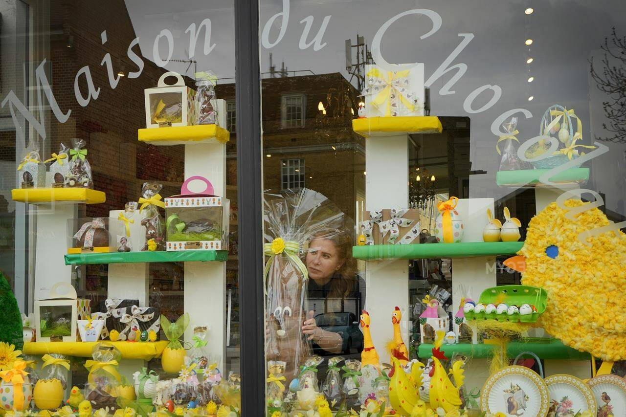 Niaz Mardan places a large luxury handmade Belgian chocolate rabbit in the window display of Sandrine a chocolate shop in south west London, Thursday, March 21, 2024. Niaz Mardan, is suffering due to high cocoa prices, she’s making no profits and fears she will have to close the shop that’s been around for 25 years (she’s the third owner and took over in 2019). (AP Photo/Kirsty Wigglesworth)