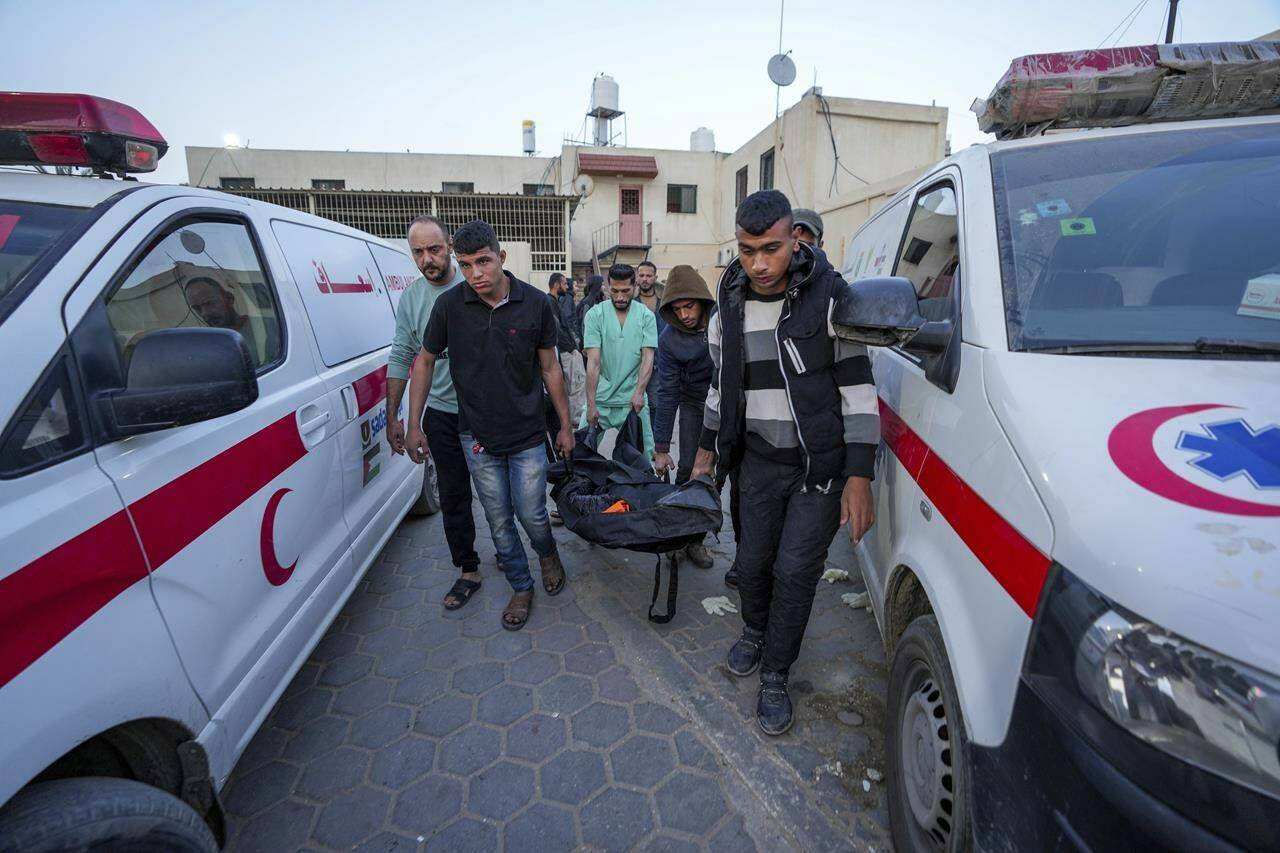 Palestinians carry the body of a World Central Kitchen worker at Al Aqsa hospital in Deir al-Balah, Gaza Strip, Tuesday, April 2, 2024. A Canadian-American citizen is among the seven aid workers who were killed by an apparent Israeli airstrike in Gaza.THE CANADIAN PRESS/AP/Abdel Kareem Hana