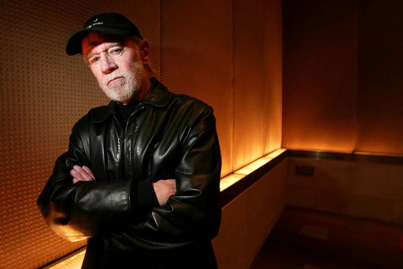 FILE - Actor and comedian George Carlin poses in a New York hotel March 19, 2004. (AP Photo/Gregory Bull, File)