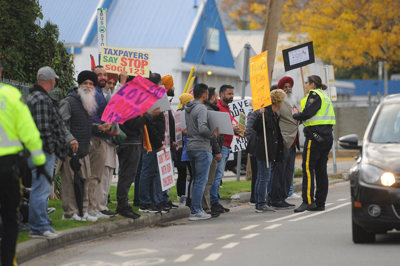 An officer asks protesters to step off the road at an anti-SOGI 123 rally in Chilliwack on Oct. 10. There has been a surge of protests in the Fraser Valley recently. The provincial government Wednesday tabled legislation to create buffer zones around schools. (Jenna Hauck/ Chilliwack Progress)