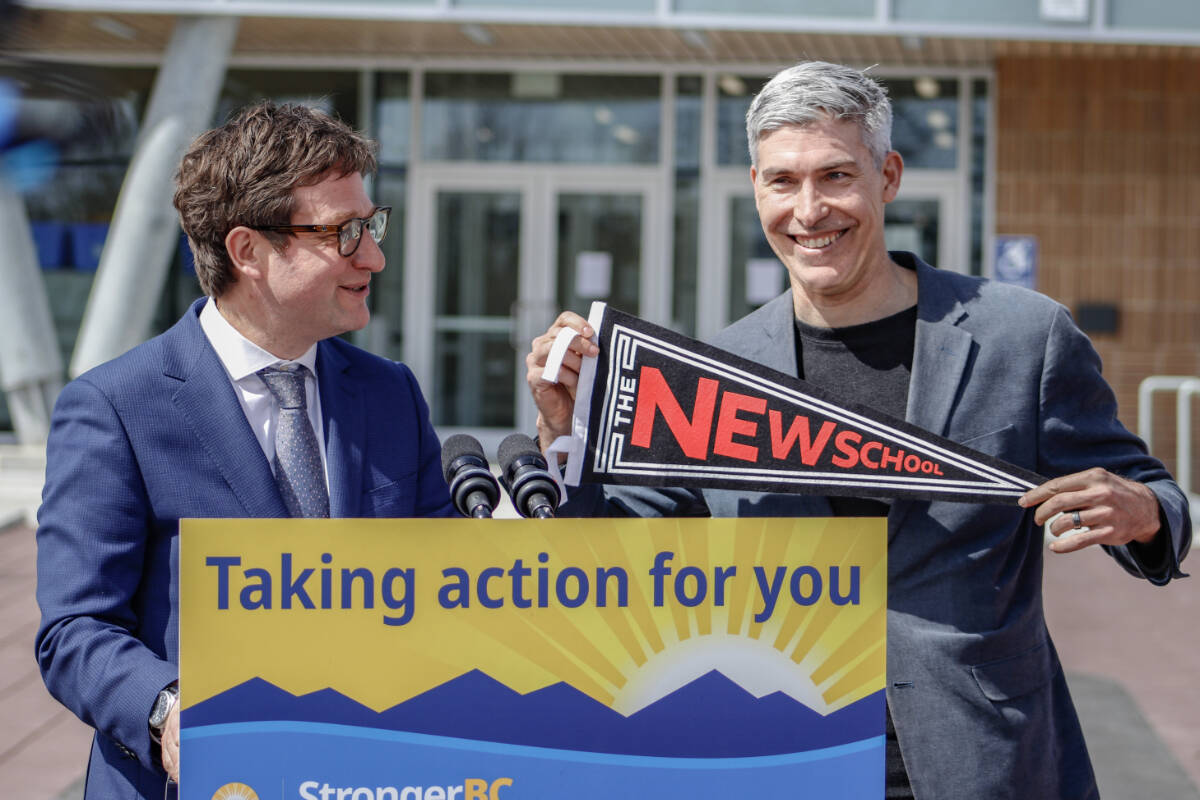 Minister of Transportation and Infrastructure Rob Fleming, left, presented Victoria High School principal Aaron Parker with a flag in celebration of the reopening of the 109-year-old building on Wednesday, April 10. (Bailey Seymour/News Staff)