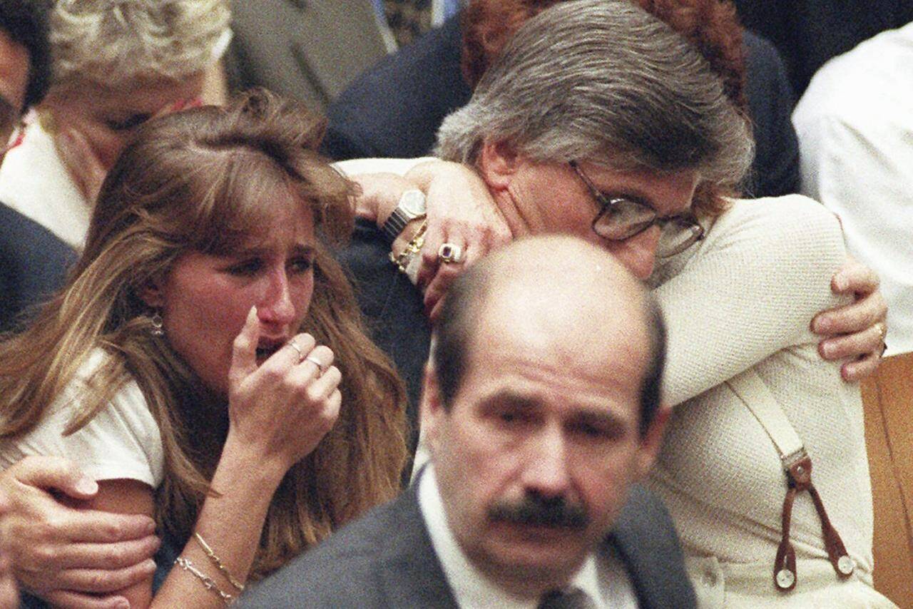 FILE - Fred Goldman, father of Ron Goldman, hugs his wife Patti, as his daughter, Kim, left, reacts during the reading of the not guilty verdicts in O.J. Simpson double-murder trial in Tuesday, Oct. 3,1995, in Los Angeles. Simpson was acquitted in the murders of Goldman and Simpson’s ex-wife Nicole. Foreground is Los Angeles Police Detective Tom Lange, co-lead investigator in the case. Simpson, the decorated football superstar and Hollywood actor who was acquitted of charges he killed his former wife and her friend but later found liable in a separate civil trial, has died. He was 76. (Myung J. Chun/Los Angeles Daily News via AP, Pool, File)