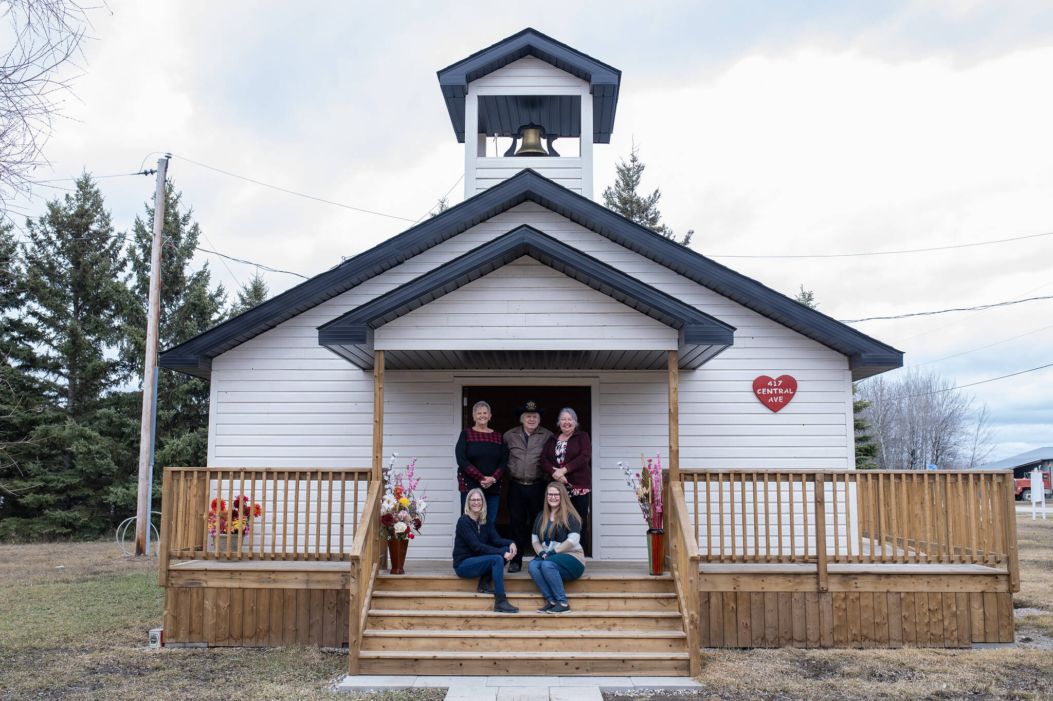 Town residents back row from left, Karen Smith, lMarvin Torwalt, and Deloris Chometsky, and front row from left, Mayor Shelley Vallier, and town administrator Jordy Hamilton stand and sit for a photograph outside the town’s newly-built wedding chapel in Love, Sask. on Thursday, April 11, 2024. THE CANADIAN PRESS/Liam Richards