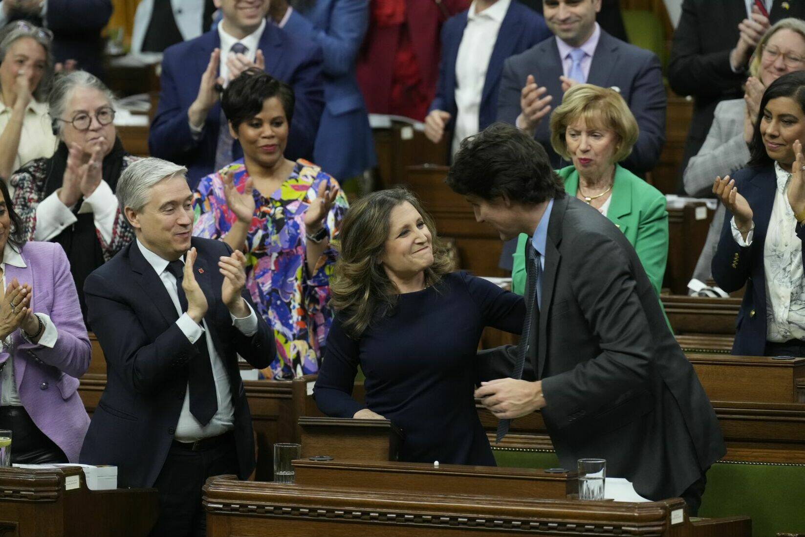 Deputy Prime Minister and Minister of Finance Chrystia Freeland receives applause as she shakes hands with Prime Minister Justin Trudeau, right, after she presented the federal budget in the House of Commons in Ottawa on Tuesday, April 16, 2024. THE CANADIAN PRESS/Adrian Wyld