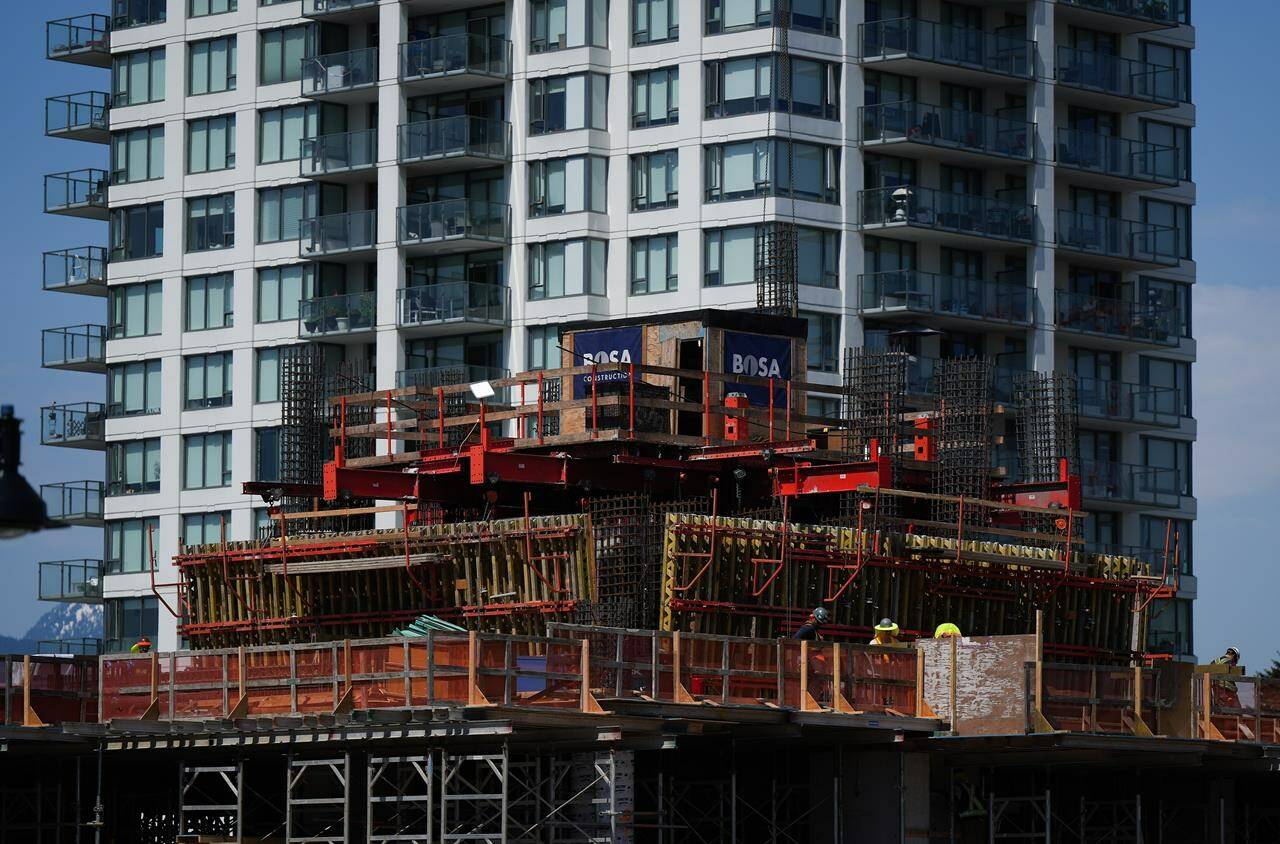 Workers are seen on a condo tower under construction in Coquitlam, B.C., on Tuesday, May 16, 2023. British Columbia’s construction industry says its workforce numbers have improved in recent years, but labour shortages persist and are putting “extreme pressures” on employers. THE CANADIAN PRESS/Darryl Dyck