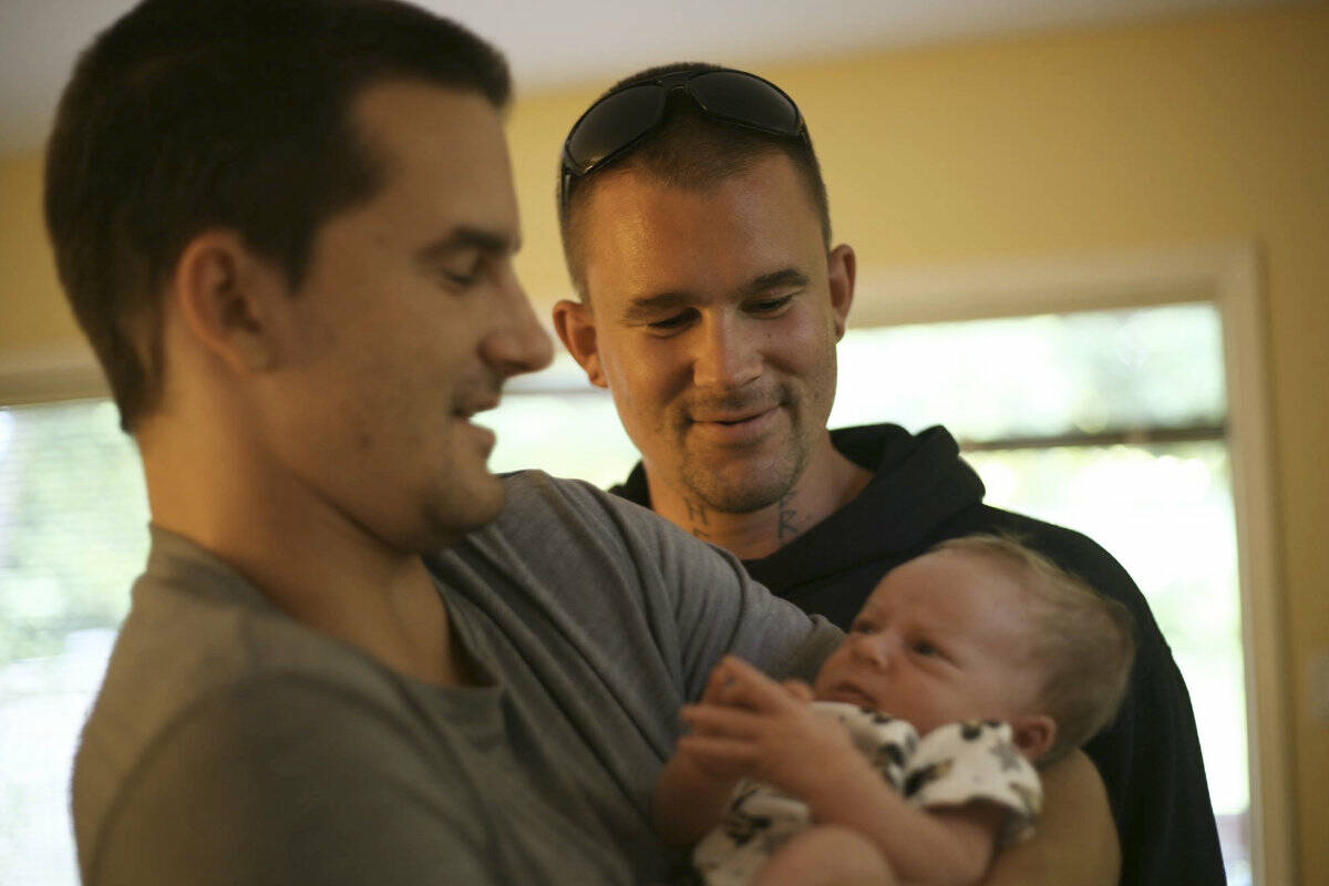 Michael Guy looks on as his brother Stefan holds one of Michael’s children. Michael died of toxic drug poisoning in Nelson in June 2023. Photo courtesy Guy family