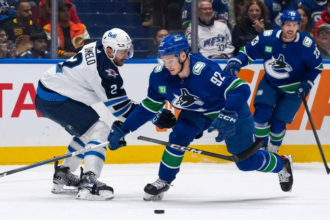 Vancouver Canucks’ Vasily Podkolzin (92) breaks Winnipeg Jets’ Dylan DeMelo’s (2) stick as they vie for the puck during the first period of an NHL game, in Vancouver, Saturday, March 9, 2024.The Canucks have signed former first-round draft pick Podkolzin to a two-year extension.THE CANADIAN PRESS/Ethan Cairns