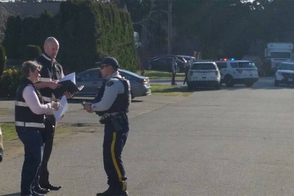 An IIO officer speaks with a Mountie at the scene of fatal March 29, 2019 shootings. (File Photo: Tom Zytaruk)