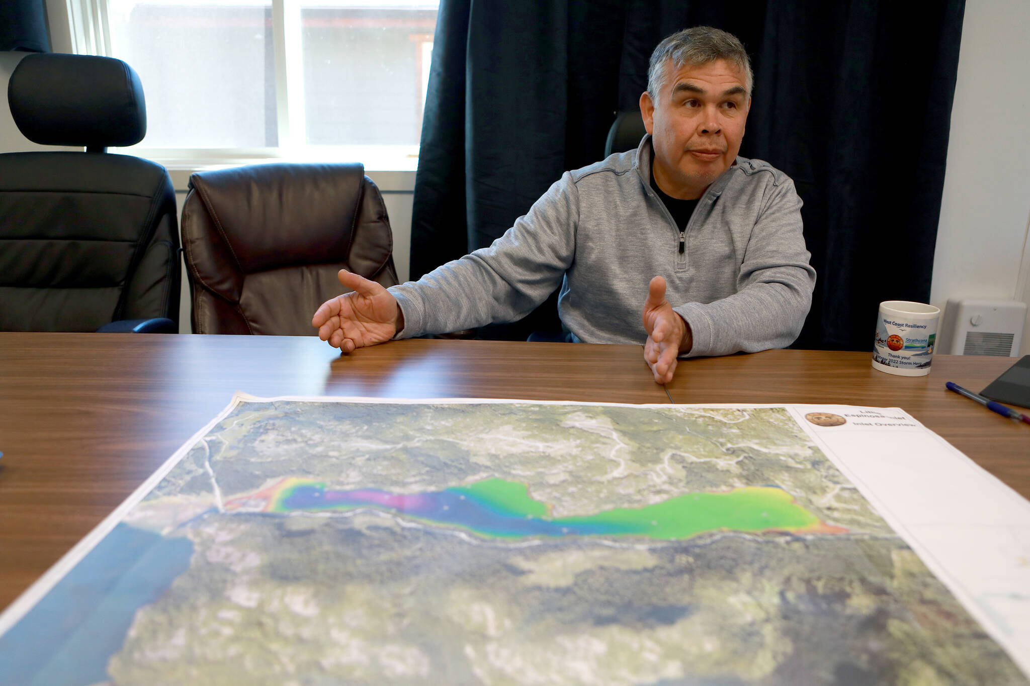 Ehattesaht Chief Simon John uses a contour map of the Espinosa Inlet to talk about a two-year-old female orca calf stranded in a lagoon in the area where her pregnant mother died nearly four weeks ago, during a meeting at the Ehattesaht First Nation’s band office, in Zeballos, B.C., Thursday, April 18, 2024. THE CANADIAN PRESS/Chad Hipolito