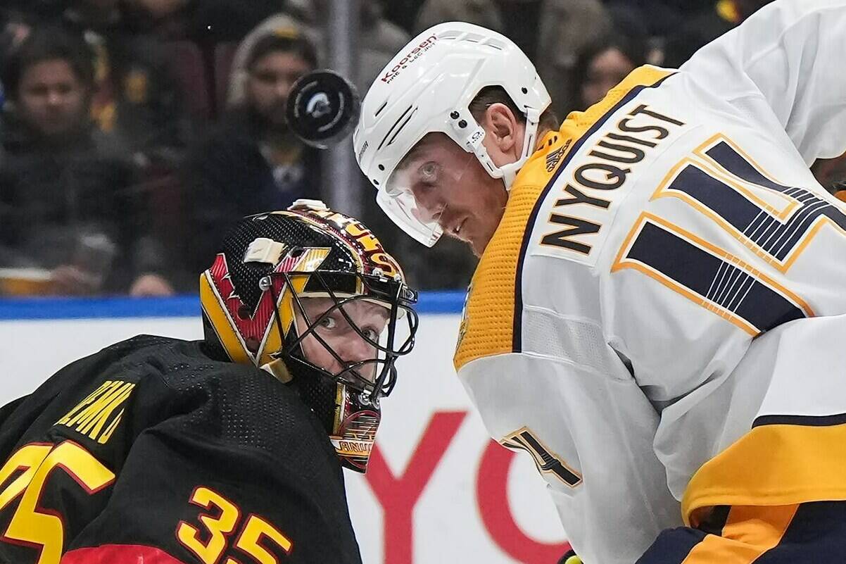 Vancouver Canucks goalie Thatcher Demko, left, and Nashville Predators’ Gustav Nyquist watch the puck during NHL action in Vancouver, on Tuesday, October 31, 2023. On Sunday, the Canucks will host their first home playoff game since 2015 when they kick off a first-round matchup against the Predators. THE CANADIAN PRESS/Darryl Dyck