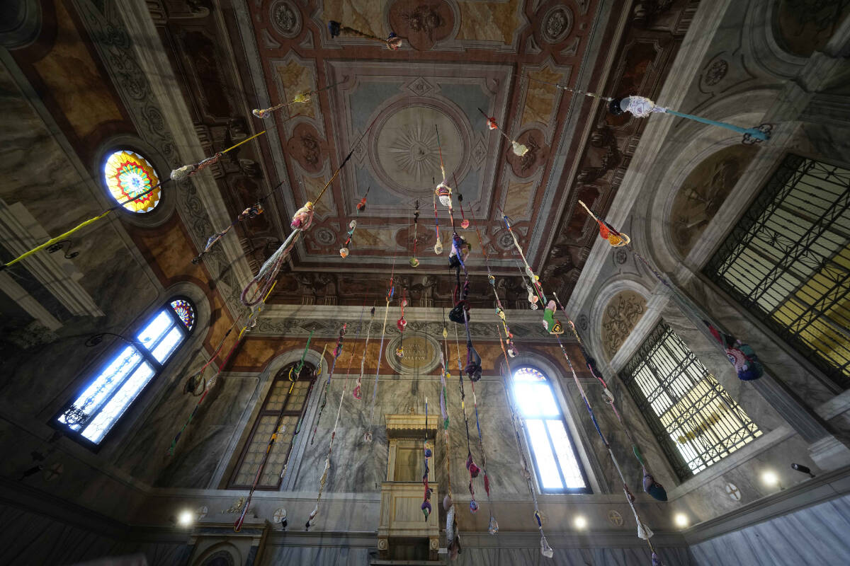 An installation by artist Sonia Gomes is displayed inside the church Santa Maria Maddalena Convertita at the women’s prison of he Giudecca island during the 60th Biennale of Arts exhibition in Venice, Italy, Wednesday, April 17, 2024. A pair of nude feet dirty, wounded and vulnerable are painted on the façade of the Venice women’s prison chapel, the work of Italian artist Maurizio Cattelan and part of the Vatican’s pavilion at the Venice Biennale in an innovative collaboration between inmates and artists. (AP Photo/Luca Bruno)