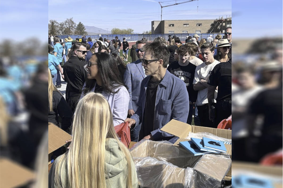 In this photo provided by Jesse Sorenson, actor Kevin Bacon, center, helps fill care packages for his charity, Saturday, April 20, 2024, in Payson, Utah, while visiting the Utah high school where cult classic “Footloose,” was filmed. (Jesse Sorenson via AP)