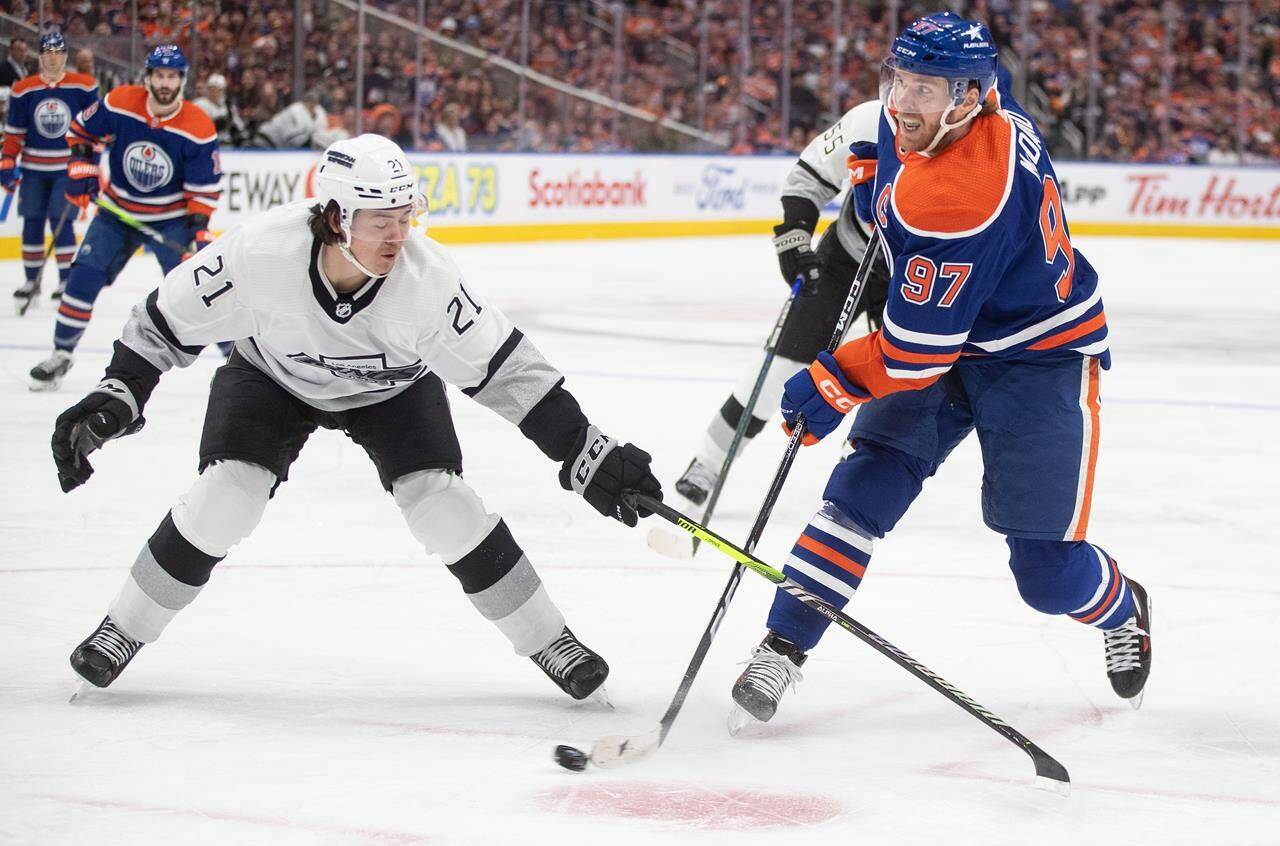 Los Angeles Kings’ Jordan Spence (21) tries to stop Edmonton Oilers’ Connor McDavid during second period of Game 1 first round NHL Stanley Cup playoff hockey action in Edmonton, Monday, April 22, 2024. THE CANADIAN PRESS/Jason Franson