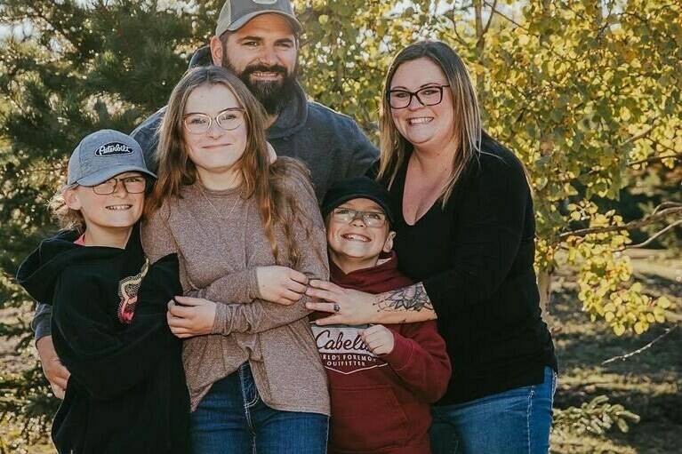 Nine-year-old Carter Vigh, wearing a red sweatshirt, is pictured with his brother Daxton (left), sister Cadence, father James and mother Amber. Carter died of asthma exacerbated by wildfire smoke in July 2023. THE CANADIAN PRESS/HO-Amber Vigh