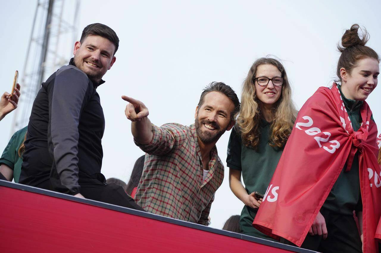 Wrexham AFC co-owner Ryan Reynolds, centre, celebrates with members of the Wrexham soccer team the promotion to League One of the English Football League in Wrexham, Wales, on May 2, 2023. Wrexham is set to play Major League Soccer’s Vancouver Whitecaps on July 27 at BC Place. THE CANADIAN PRESS/AP/Jon Super