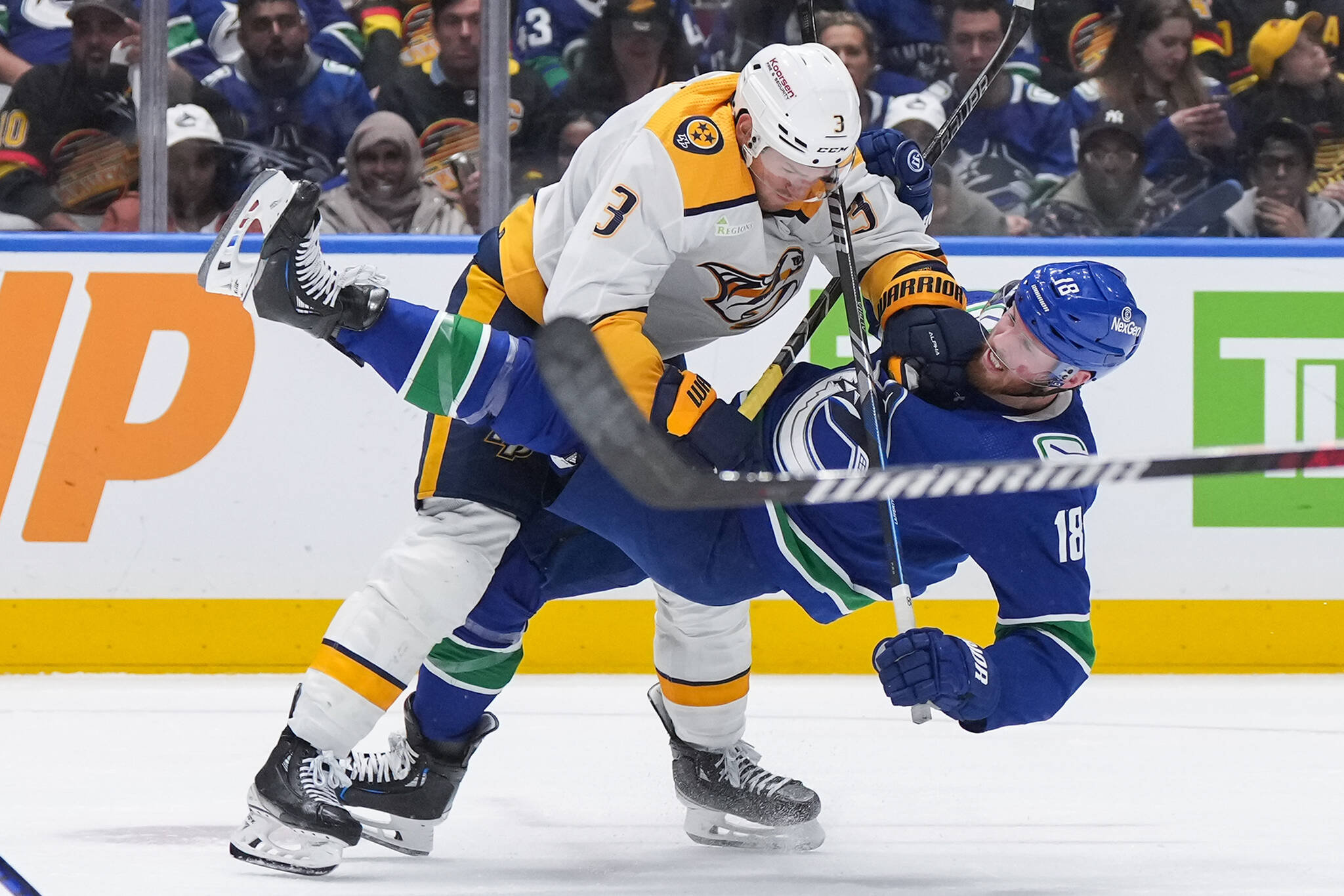 Nashville Predators’ Jeremy Lauzon, left, checks Vancouver Canucks’ Sam Lafferty during the third period in Game 2 of an NHL hockey Stanley Cup first-round playoff series, in Vancouver, on Tuesday, April 23, 2024. THE CANADIAN PRESS/Darryl Dyck