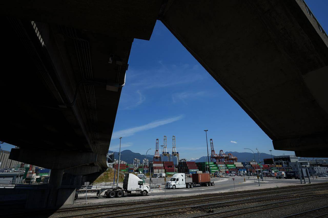 The head of Canada’s biggest trucking firm says the U.S. election is softening an already weak market for freight. A transport truck carries a cargo container at port in Vancouver, on Friday, July 14, 2023. THE CANADIAN PRESS/Darryl Dyck