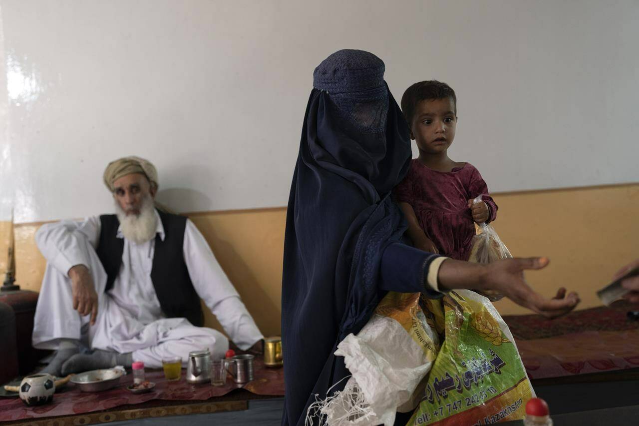 Ottawa has plans to ensure Canadian aid can finally flow to Afghanistan this year. But by the time its new system is fully up and running, the Taliban will have been in control of the country for about three years. A woman wearing a burqa begs while carrying her daughter inside a tea shop in Kabul, Afghanistan, Thursday, June 8, 2023. THE CANADIAN PRESS/AP-Rodrigo Abd
