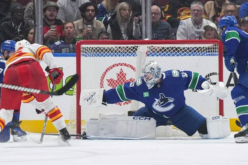 Vancouver Canucks goalie Thatcher Demko (35) stops Calgary Flames’ Martin Pospisil, front left, during the second period of an NHL hockey game in Vancouver, on Tuesday, April 16, 2024. THE CANADIAN PRESS/Darryl Dyck