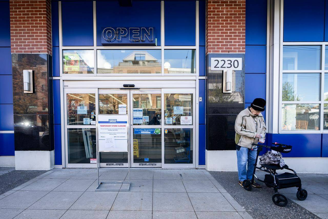 A woman waits outside of the London Drugs Broadway and Vine location in Vancouver on Monday, April 29, 2024. London Drugs is investigating the extent to which data may have been compromised in a cybersecurity incident that has prompted the company to close all of its stores across Western Canada until further notice. THE CANADIAN PRESS/Ethan Cairns